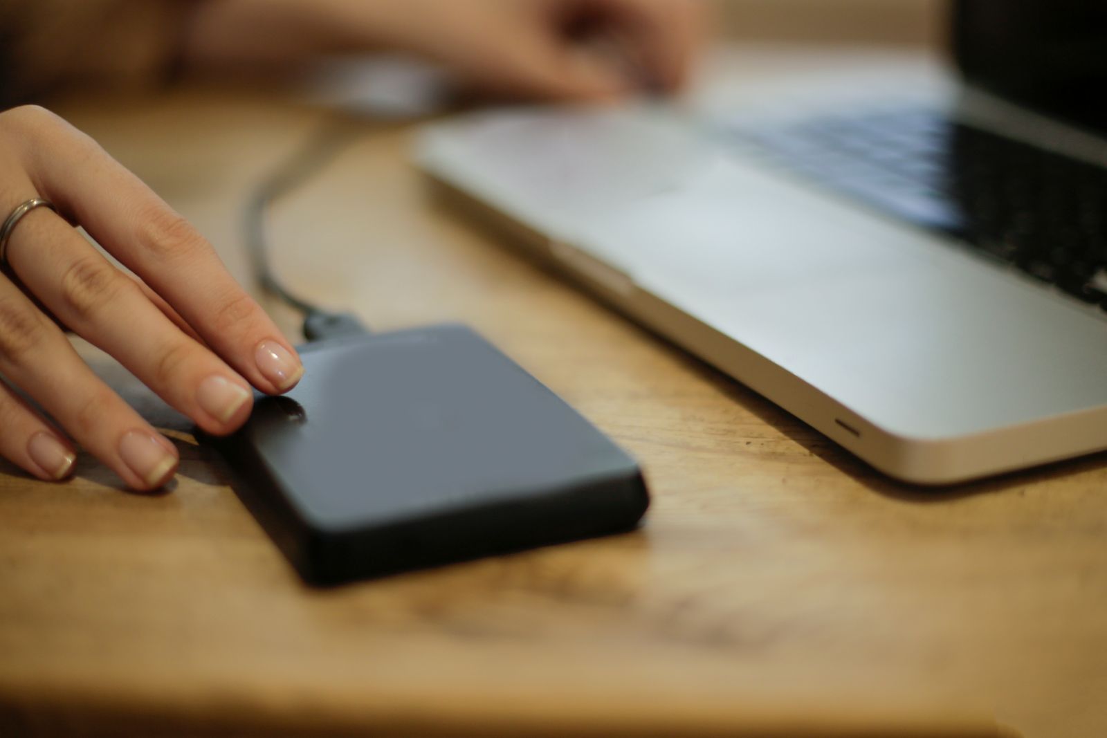 Personne en train de connecter un disque dur externe a un ordinateur portable