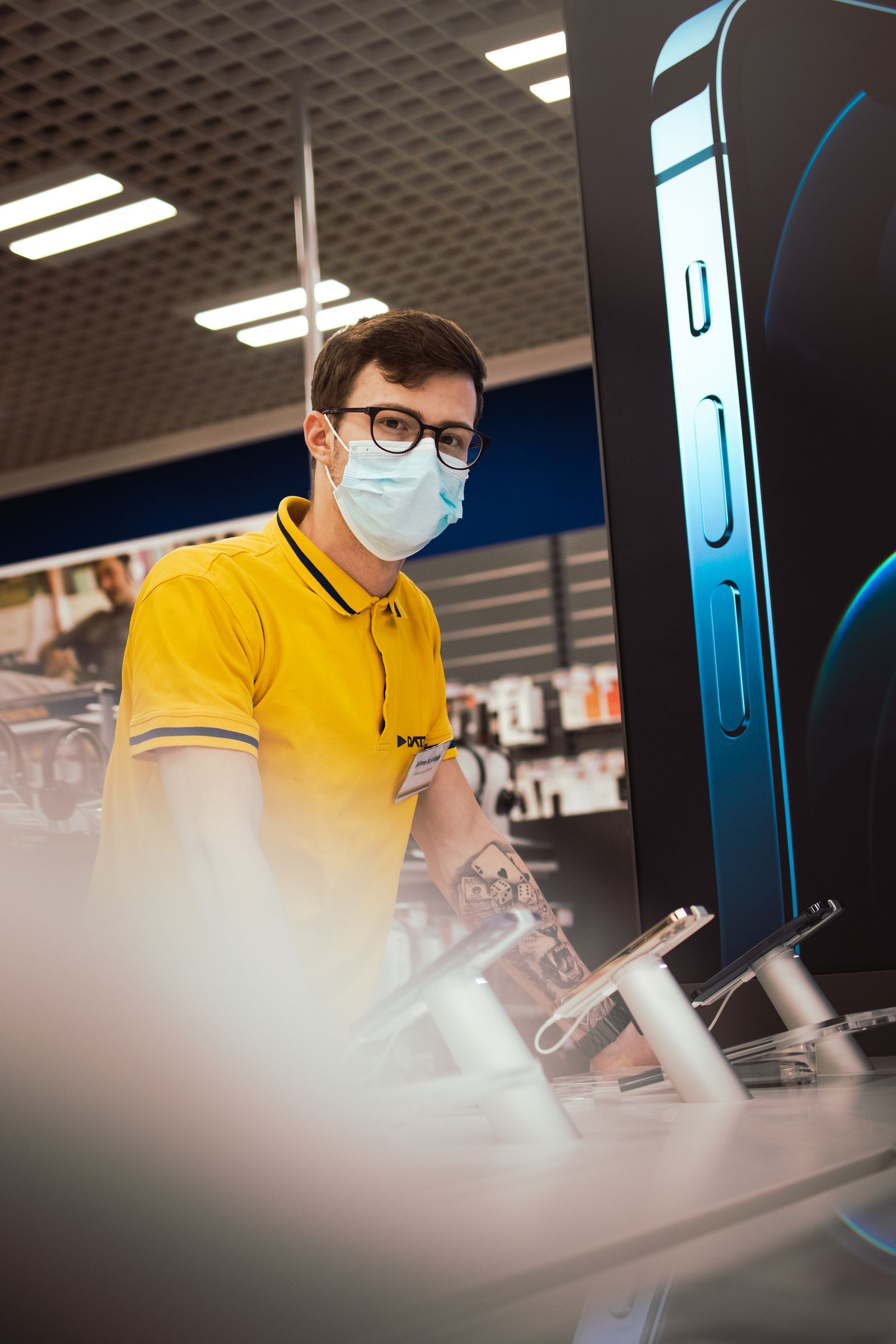 Employe presentant des appareils electroniques en magasin