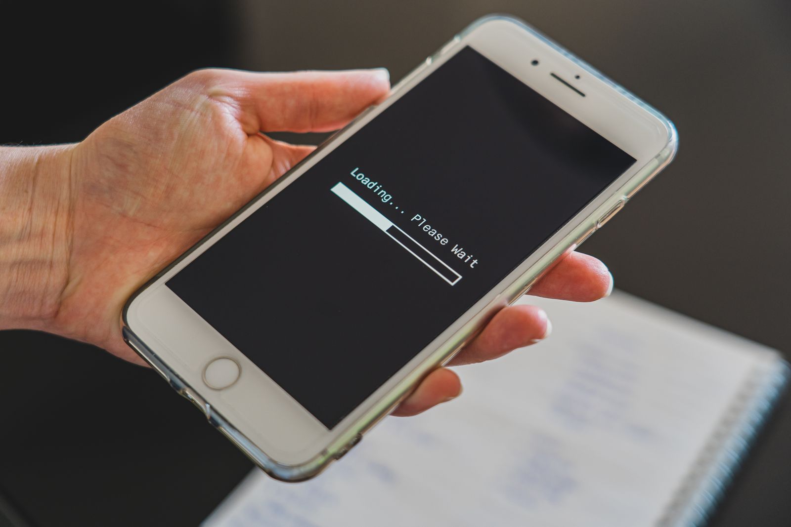 Main tenant un smartphone avec ecran de chargement