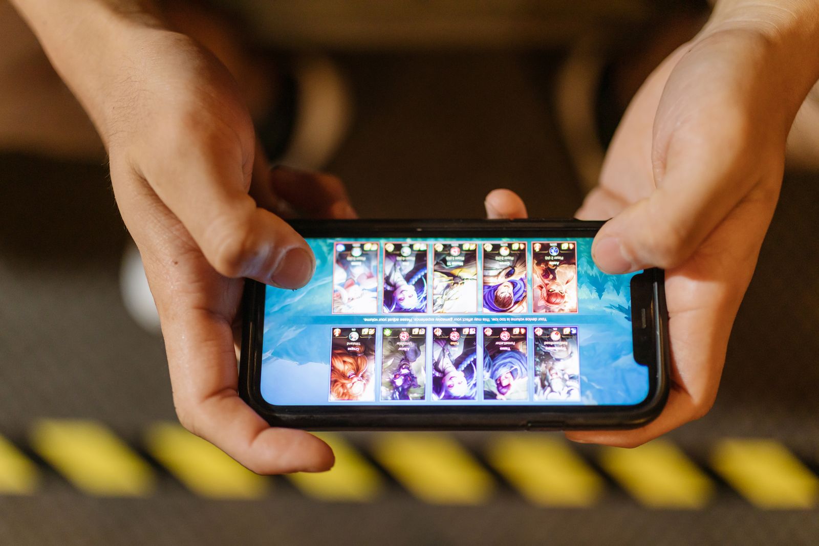 Mains tenant un smartphone pendant une session de jeu