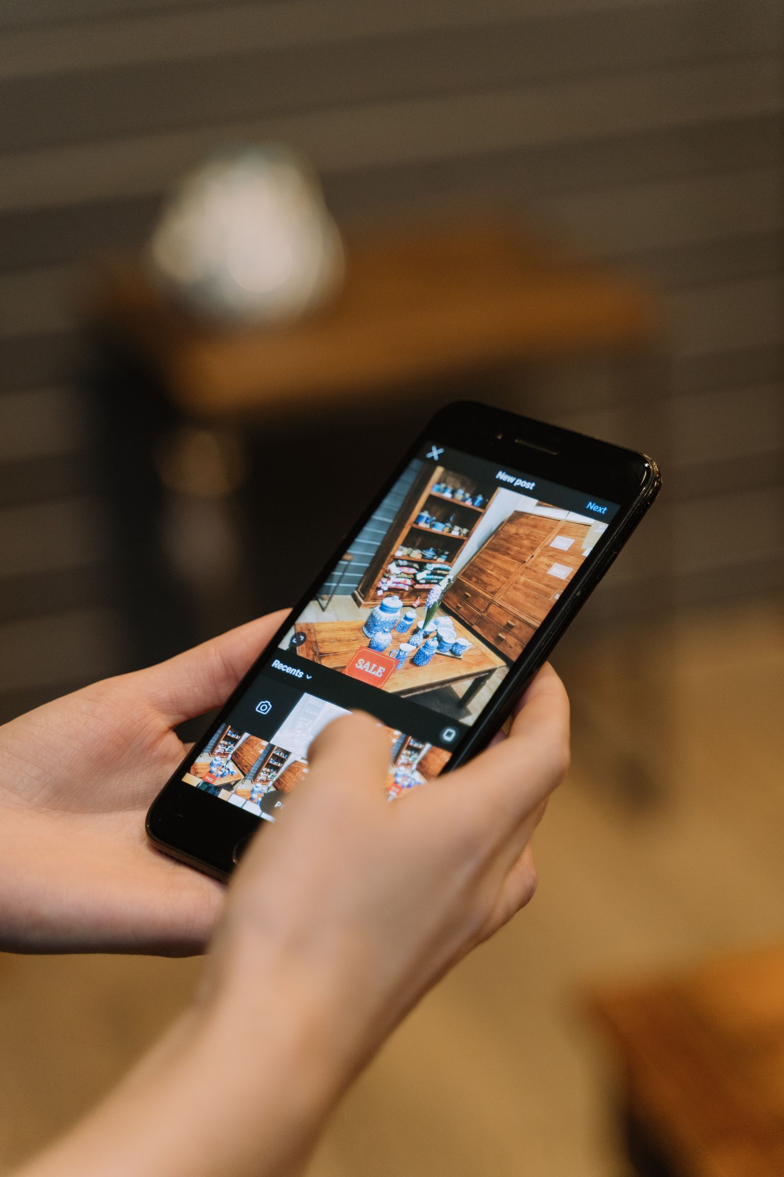 Personne tenant un smartphone pres d'un presentoir de vente