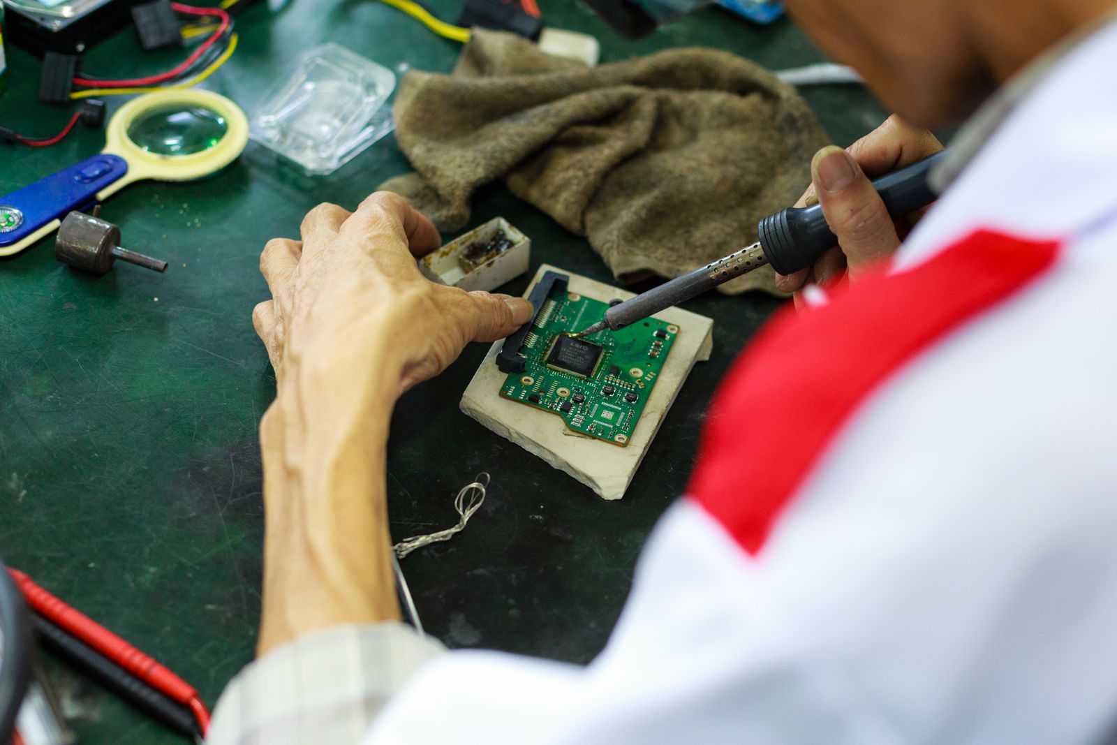 Technicien reparant un circuit electronique de precision