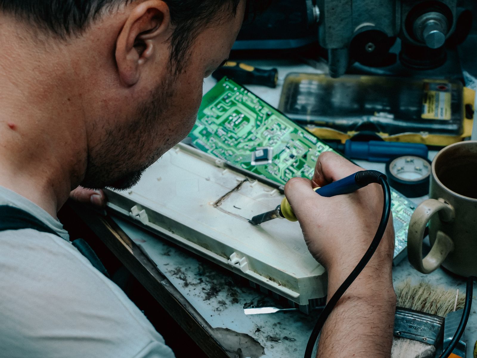 Technicien reparant un appareil electronique avec fer a souder