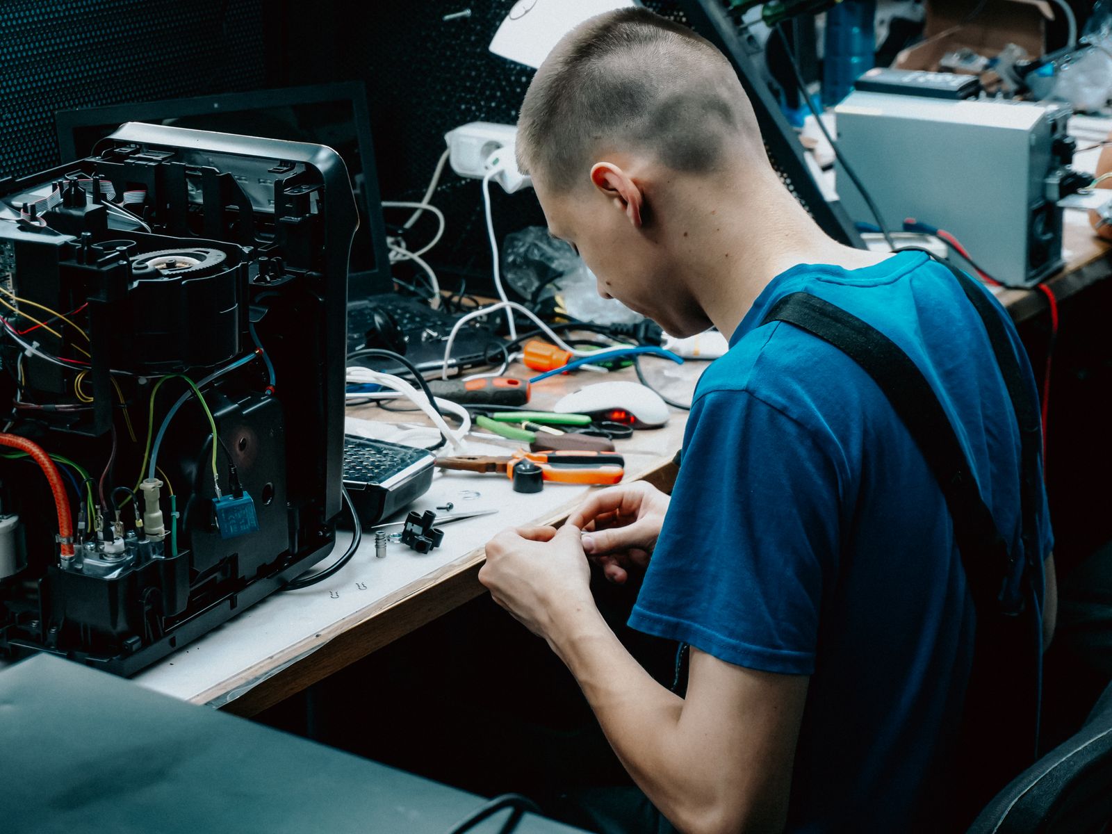 Technicien reparant un appareil electronique en atelier