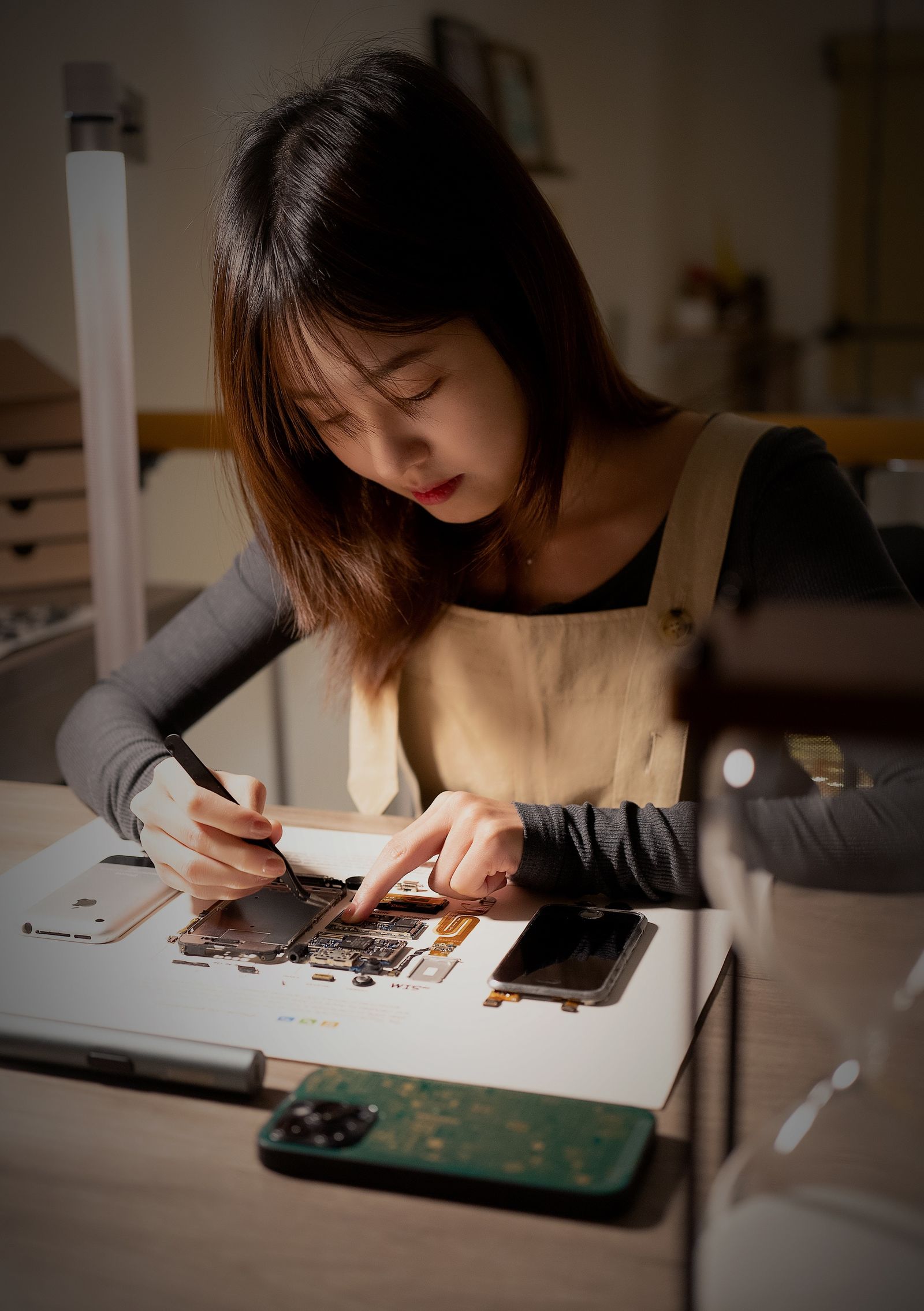 Technicienne reparant un smartphone dans un atelier